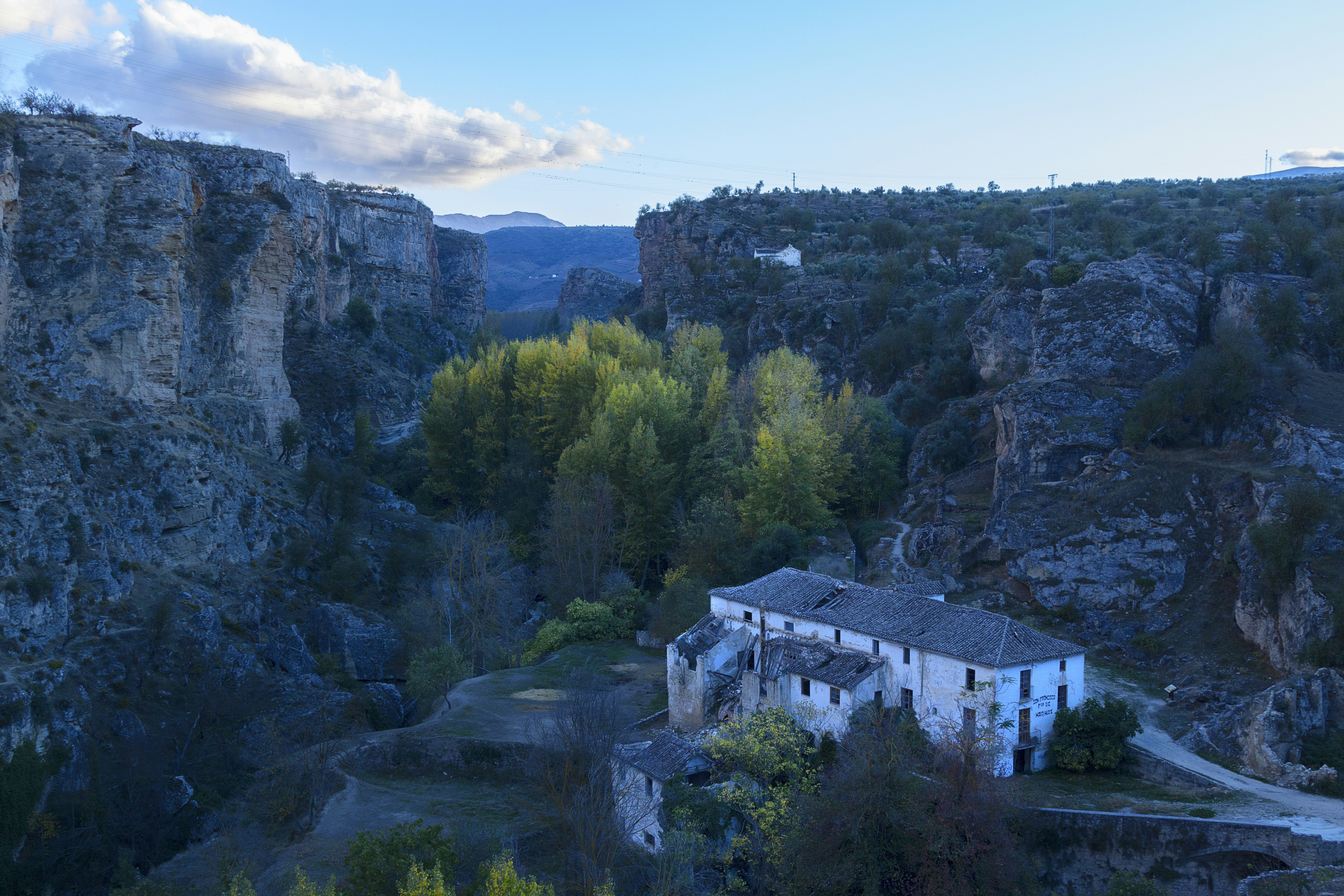 aerial photo of house near mountain, Fábrica de harinas abandonada situada entre los tajos que bordean la bella ciudad de Alhama de Granada. Está siendo invadida por la vegetación circundante. Al atardecer de un dia que visité este espacio hice esta foto.