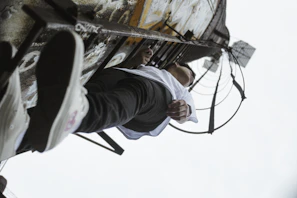 Action shot of a person climbing a ladder wearing the safety boots, emphasizing grip and support.