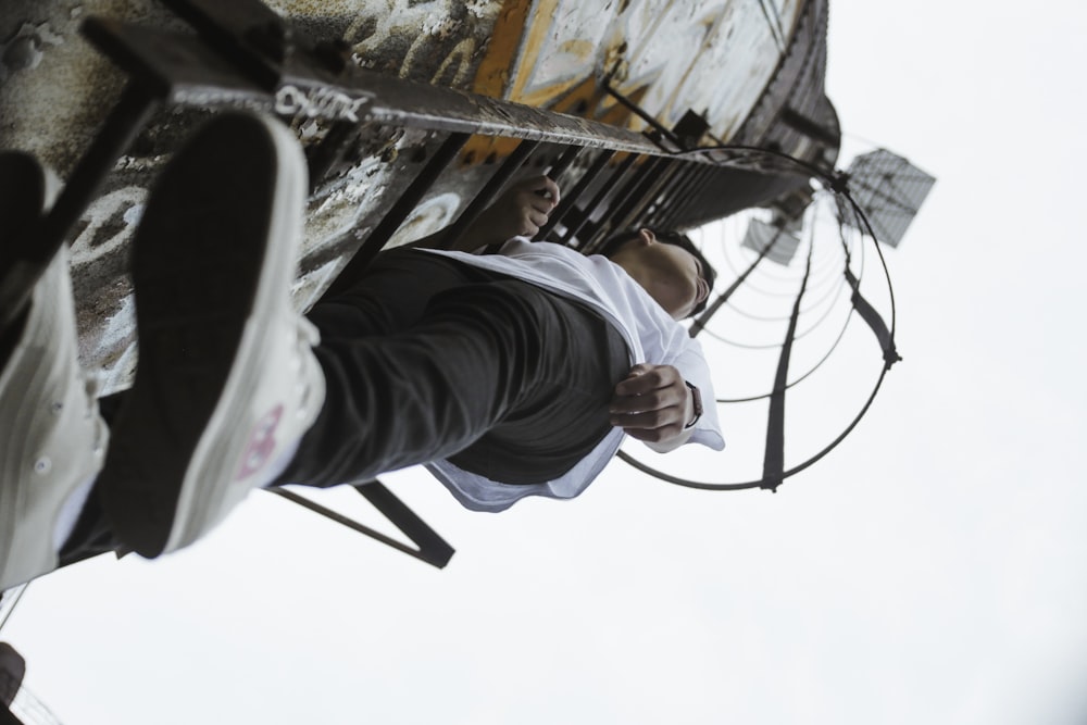 boy climbing on metal ladder