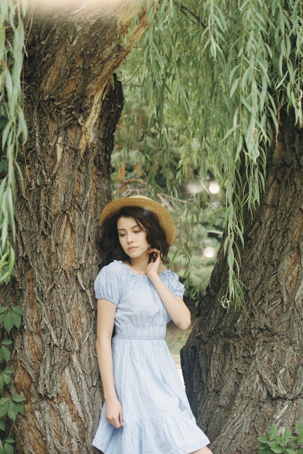 woman leaning on brown tree