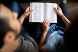 Close-up of a couple reading Clement's marriage counseling book together in a cozy setting.