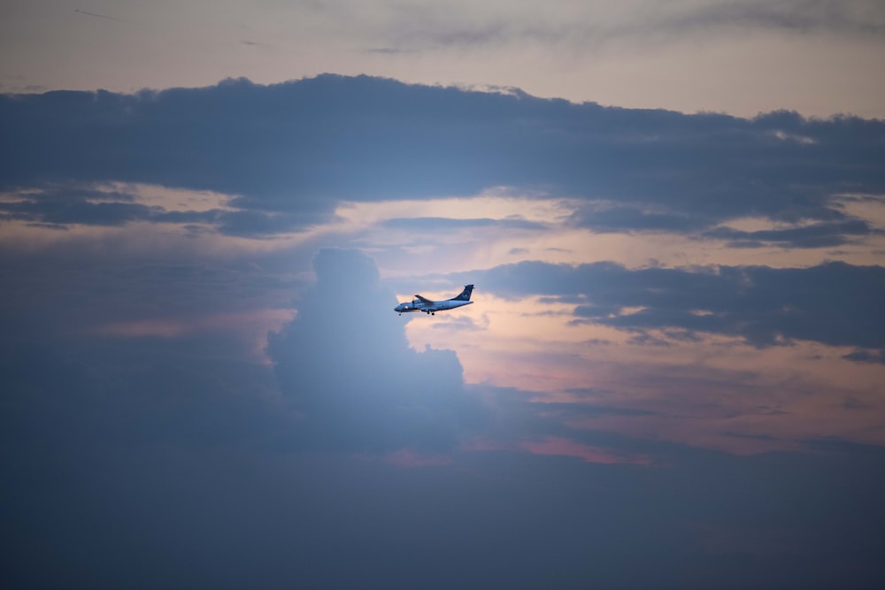 airplane in mid-air under cloudy skies