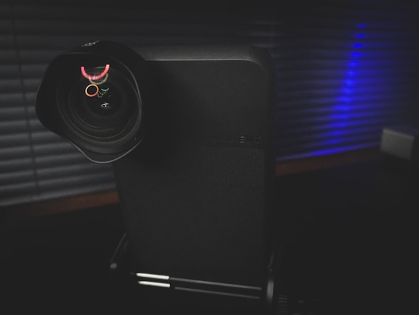 A film camera lens reflecting a colorful movie set in action.