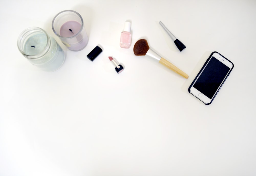 silver iPhone 6 beside makeup brush