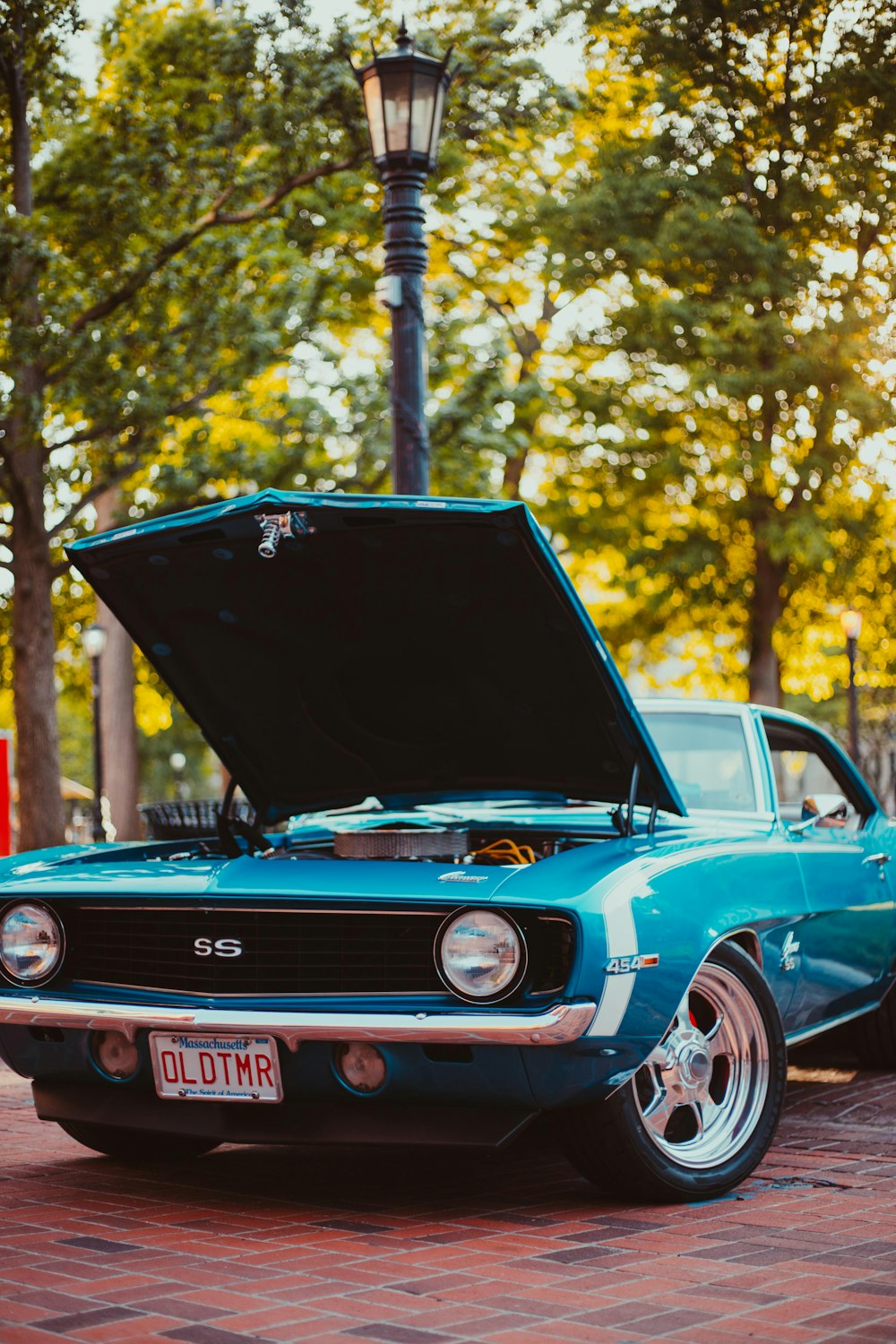 teal Chevrolet SS coupe parked near lamp post