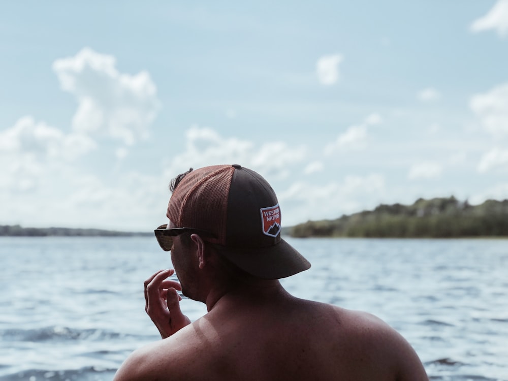 man standing near sea under white clouds during daytime