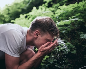 A serene morning scene with a person applying a refreshing facial spray outdoors