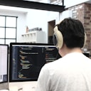 man wearing headphones while using computer