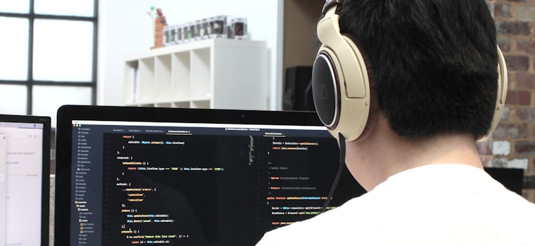 man wearing headphones while using computer