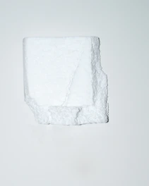 Close-up of white EPS foam cornice with reinforced coating being fixed to exterior wall.