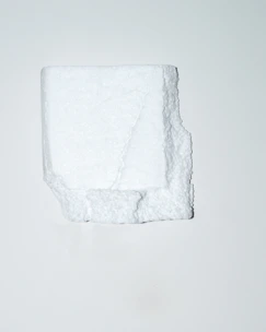 Close-up of white EPS foam cornice with reinforced coating being fixed to exterior wall.