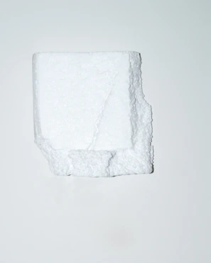 Close-up of a white EPS foam cornice with a smooth, durable red-coated surface.