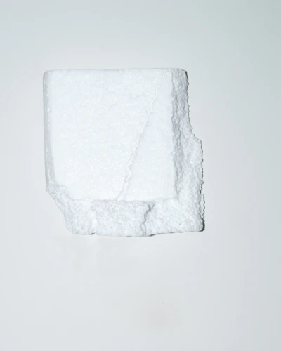 Close-up of a white EPS foam cornice with a smooth, durable red-coated surface highlighting its lightweight texture.