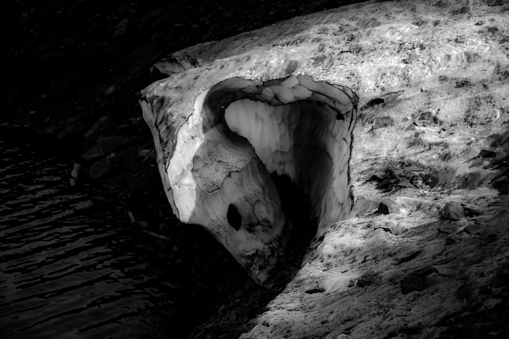 grayscale photo of cave with water