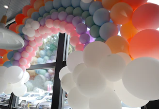 Colorful balloon arch framing a joyful birthday party scene.