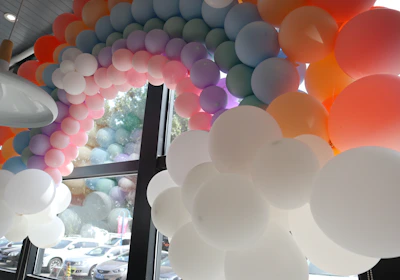 Colorful balloon arch framing a joyful birthday party scene.