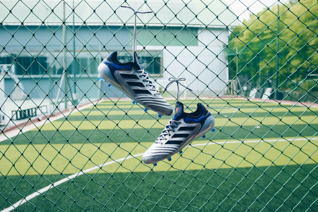 A pair of football boots hung up on a fence