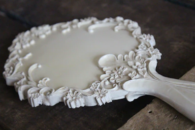 An elegant wooden mirror frame with delicate hand-carved motifs, reflecting artisanal skill.