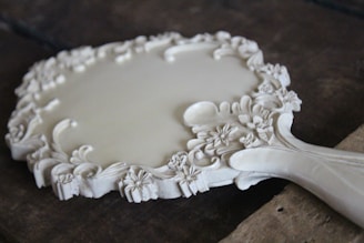A romantic hand mirror featuring intricate seashell designs.