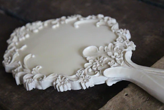 An elegant wooden mirror frame with delicate hand-carved motifs, reflecting artisanal skill.