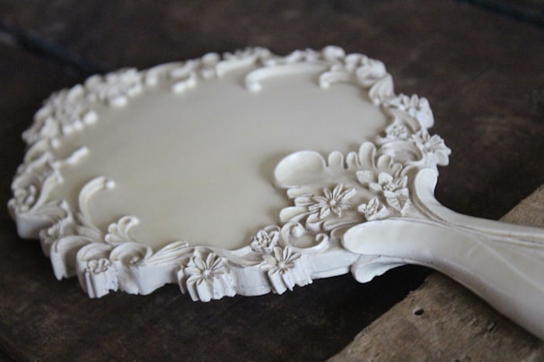 A romantic hand mirror featuring intricate seashell designs.