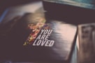 selective focus photography of You Are Loved book