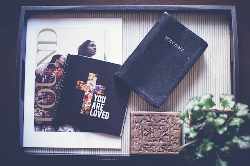 Soft pastel-toned flat lay of a journal, fitness gear, and a Bible on a cozy linen surface.