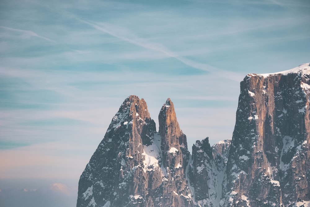 a group of mountains covered in snow under a blue sky