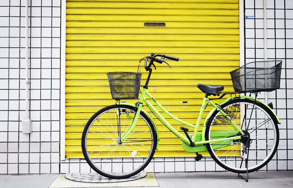 bici da crociera verde vicino al cancello giallo