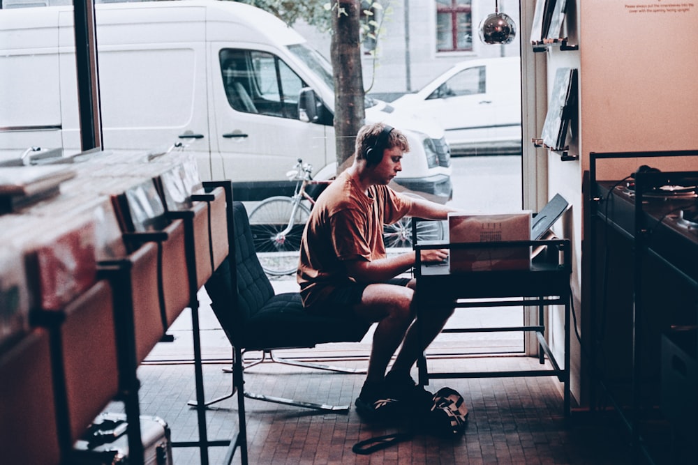 man sitting on black padded chair