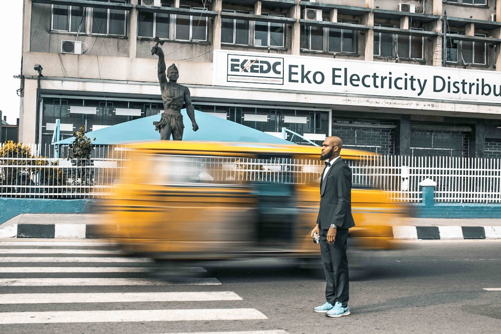 man standing at grey concrete road