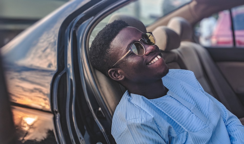 Hombre sonriente sentado dentro del vehículo durante el día