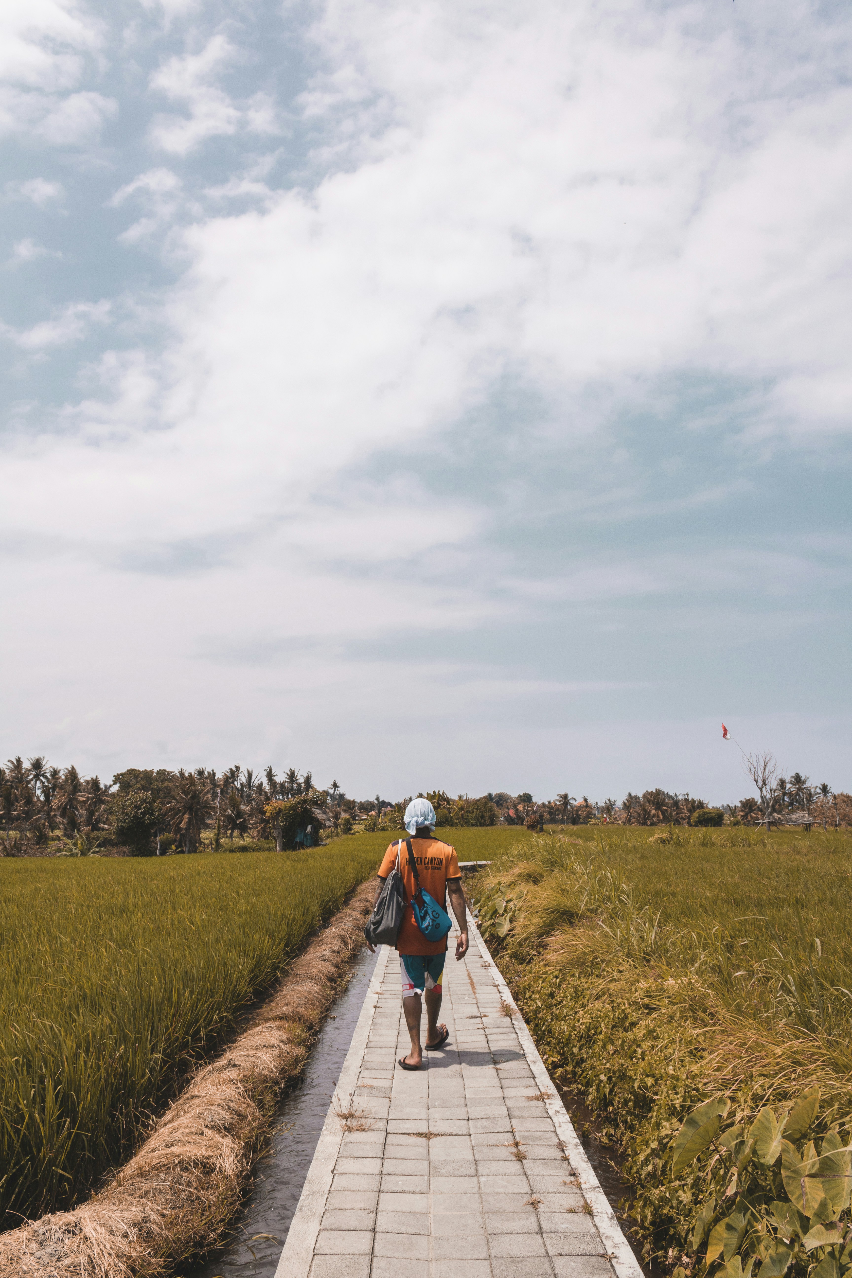 homem caminhando no caminho ao lado da coroa de flores