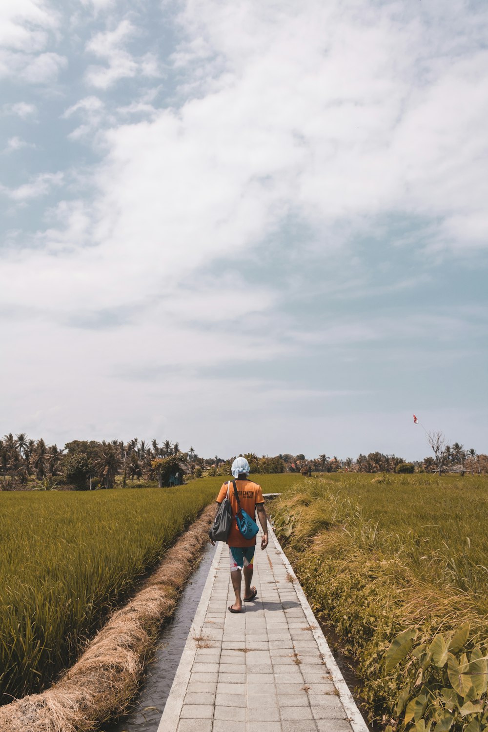 man walking on pathway beside wreath