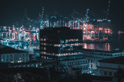 Night view of Quva Turan Türk with illuminated buildings and active logistics operations