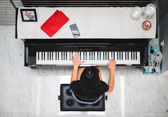 woman playing piano near white wall inside room
