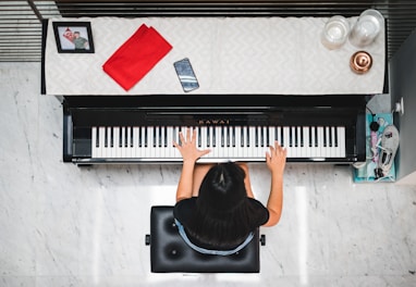 woman playing piano near white wall inside room