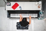 woman playing piano near white wall inside room