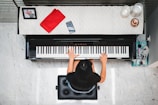 woman playing piano near white wall inside room