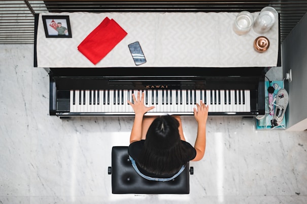 woman playing piano near white wall inside room