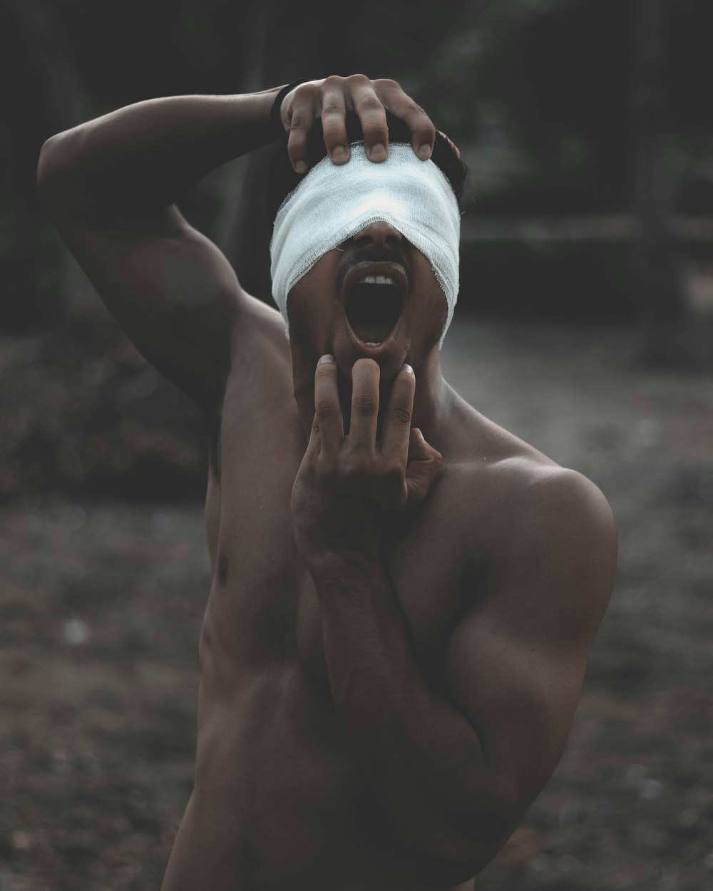 photo of topless man with bandage on his eyes