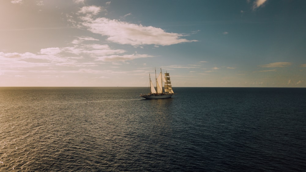 sailboat in middle of ocean under blue sky