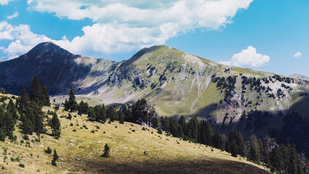 Photo aérienne de montagnes vertes sous ciel bleu et blanc