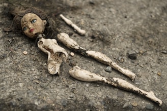 An abandoned doll lying on a dusty floor, its eyes seeming to follow you.
