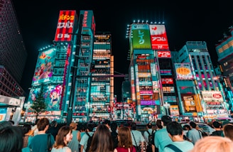 group of people watching lighted clear, red, and green high-rise building