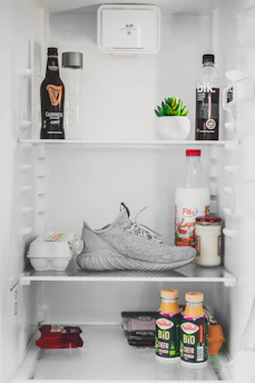 A shiny stainless steel refrigerator stocked with fresh groceries.