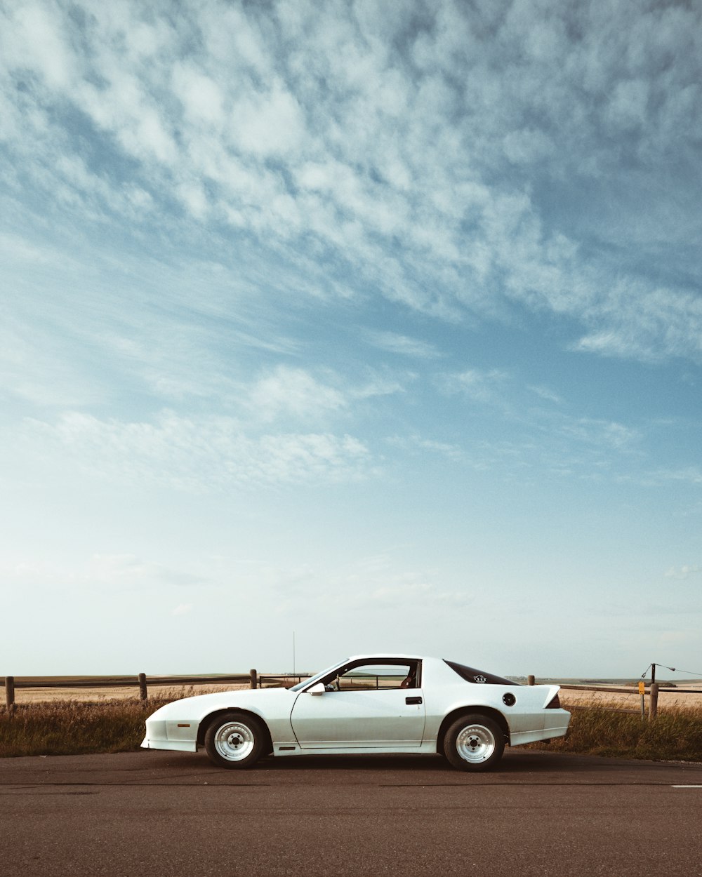 silver coupe under cloudy sky