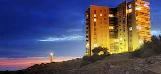 Evening view of the apartment building illuminated softly under twilight skies.