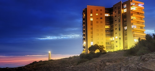 Elegant modern apartment building illuminated softly under a twilight sky with northern lights.