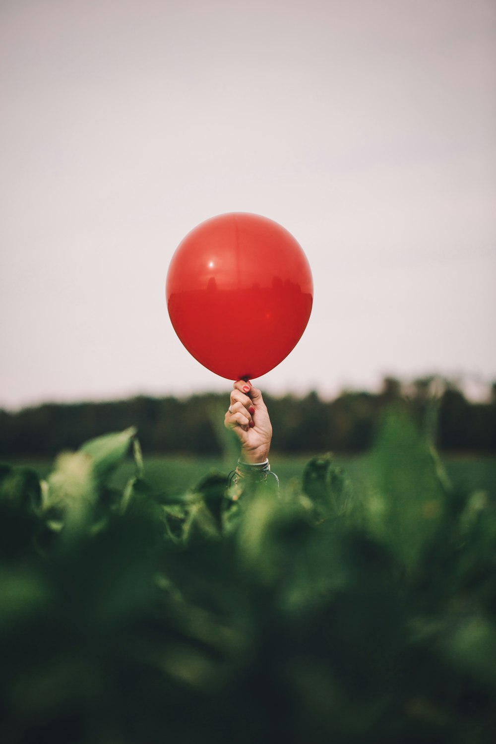 Persona sosteniendo un globo rojo
